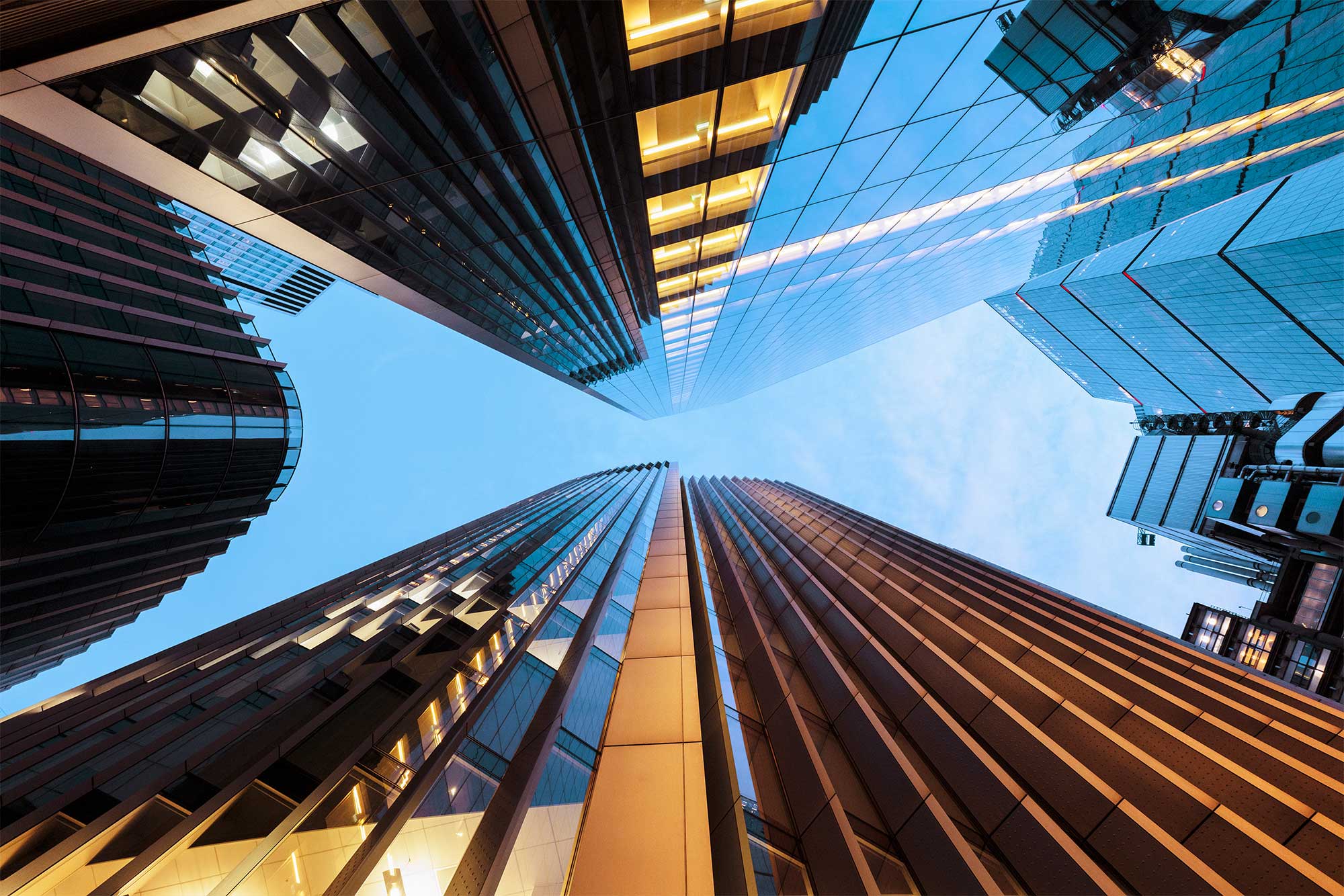 Looking up at illuminated skyscrapers